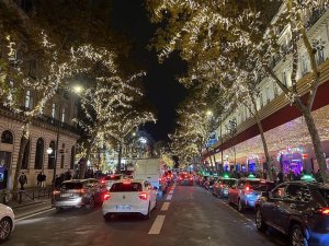 nighttime view of Boulevard Haussmann in Paris with illuminated buildings and streetlights